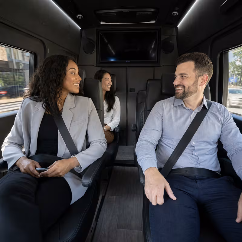 Group boarding a white charter bus for Corporate Transportation transportation in Newark
