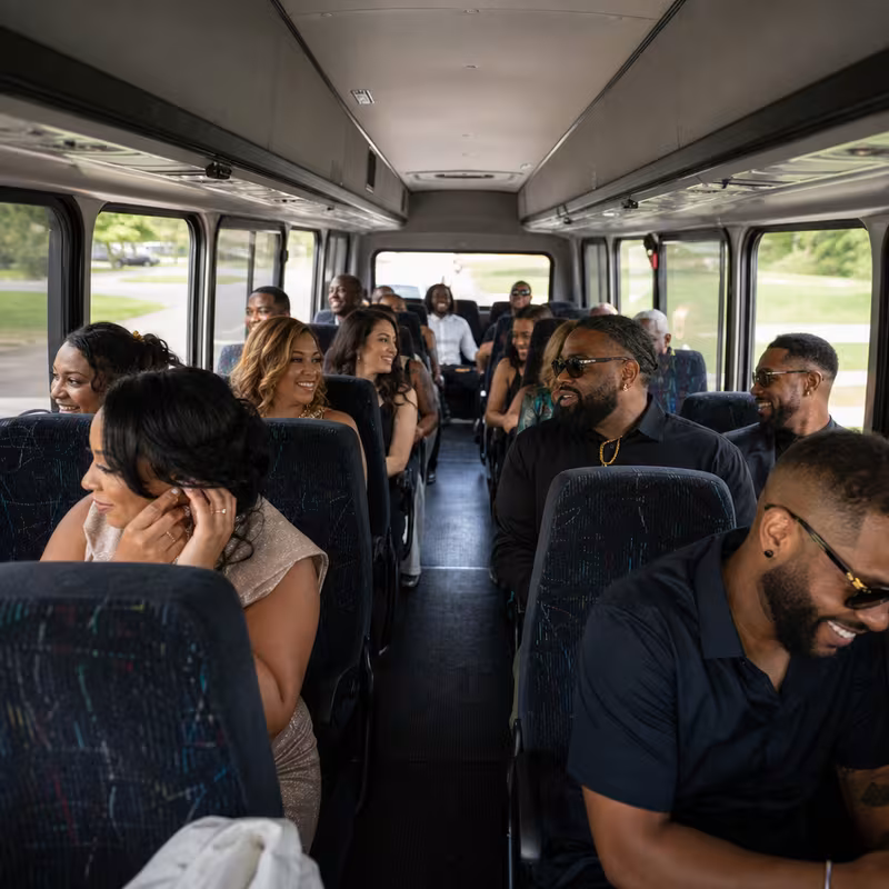 Group boarding a white charter bus for Private Event Transportation transportation in Newark