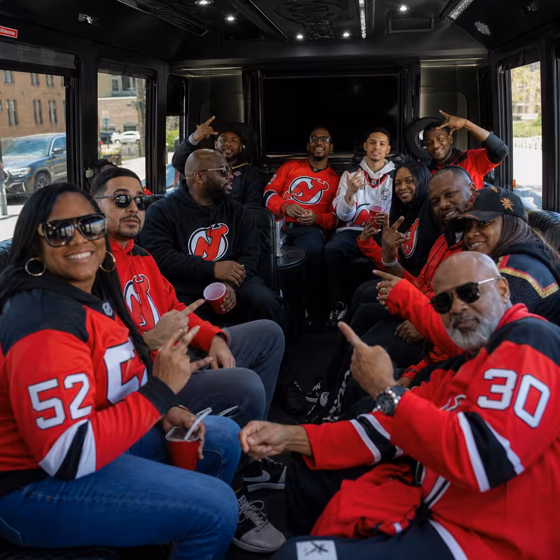 Group boarding a white charter bus for Sporting Event Transportation transportation in Newark