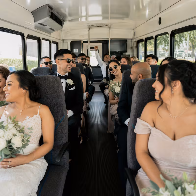 Group boarding a white charter bus for Wedding Transportation transportation in Newark